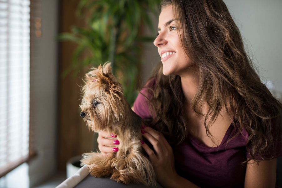 Chica con su perro viendo por la ventana